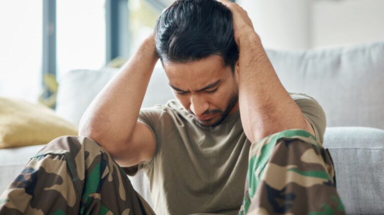 Depressed Soldier Sitting on the Floor with Head in Hands