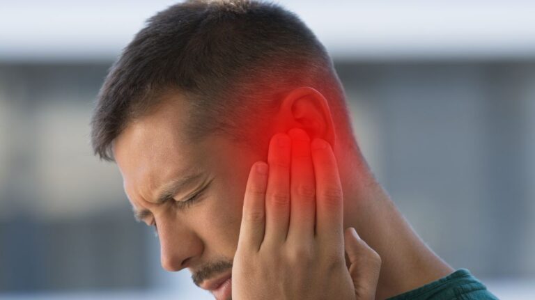 Man Holding Ear with Red on the Ear