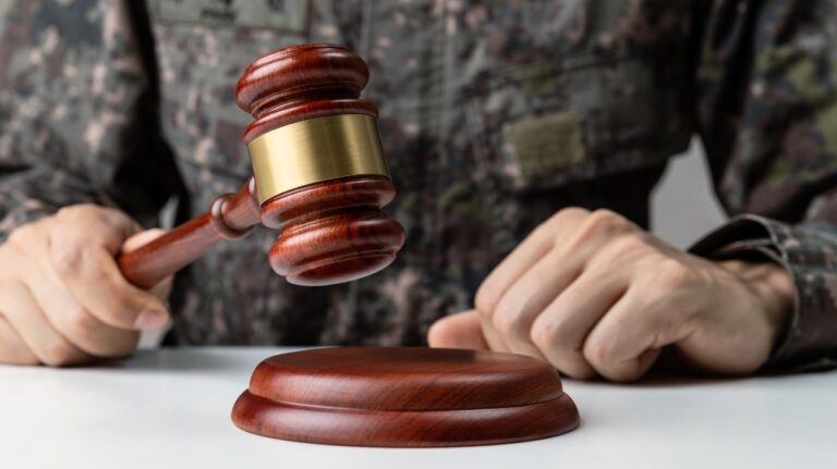 Hand of soldier holding gavel at courtroom