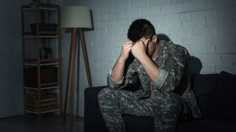 Military veteran in uniform suffering from emotional distress at home