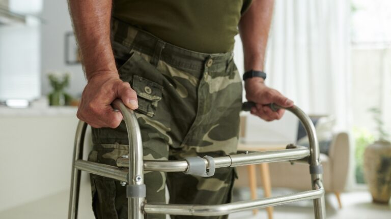 Veteran in uniform using walk helper