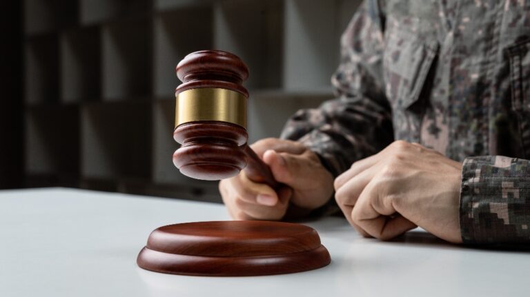 Hand of soldier holding gavel