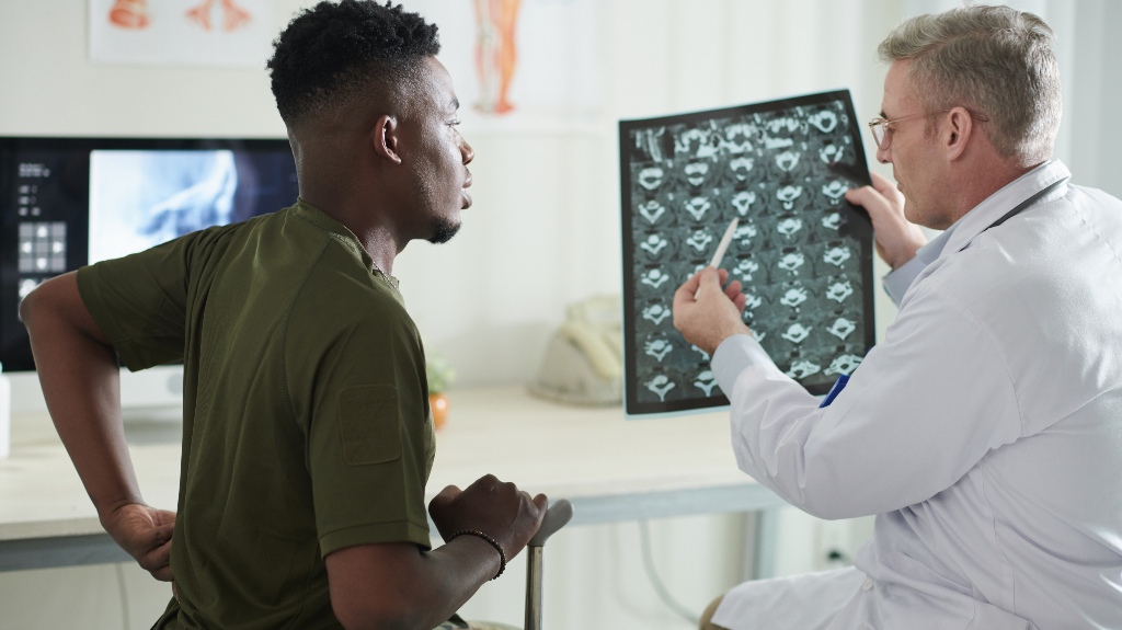 Doctor talking to military man about back pain