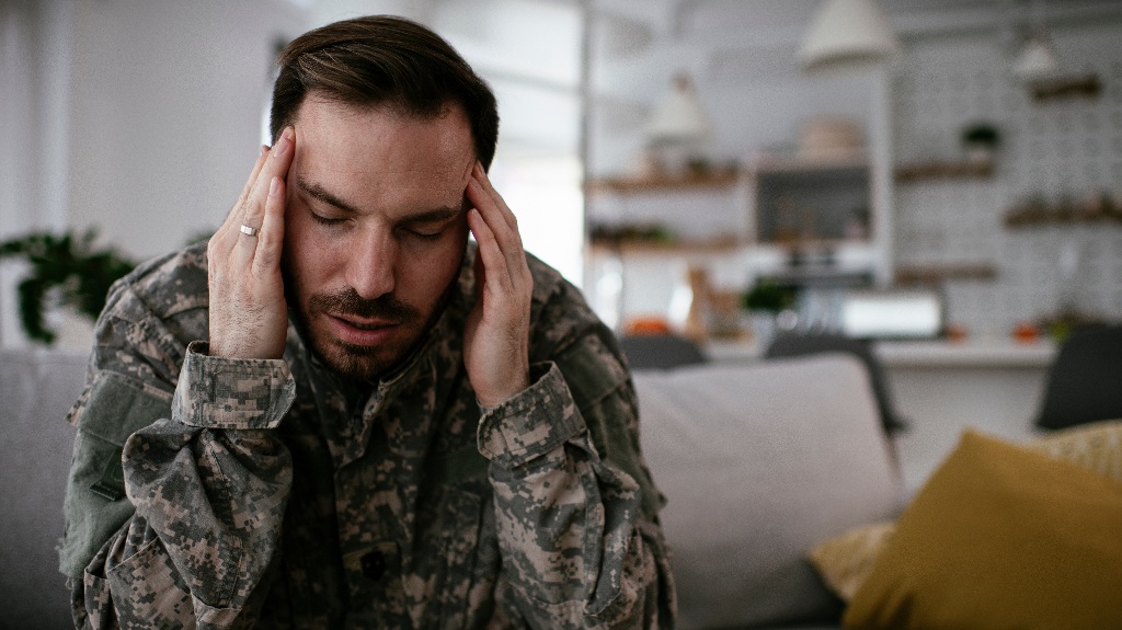 veteran clutches his head while suffering from a migraine