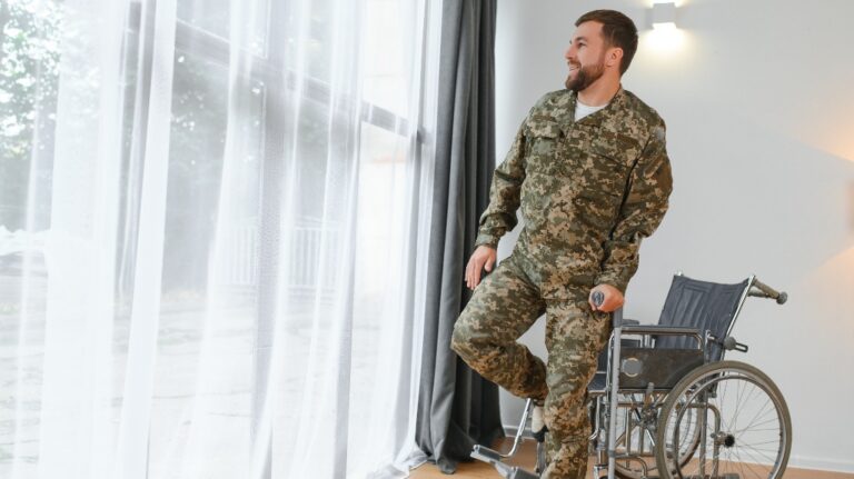 soldier in military uniform gets up from a wheelchair