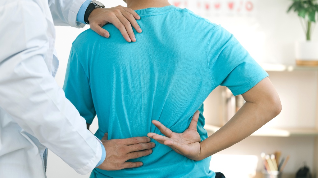 Doctor physiotherapists treat lower back pain in patients in the hospital