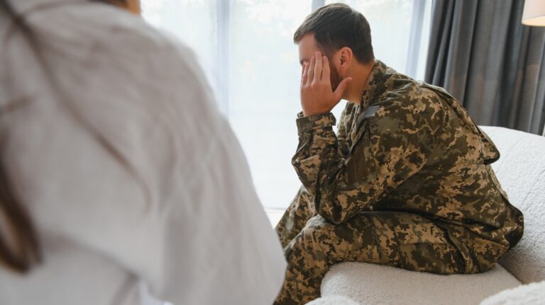 Sad male soldier on appointment with psychologist at office
