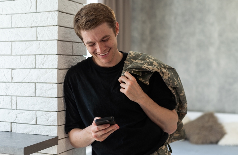 Soldier talking by mobile phone at home